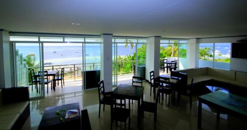 a dining room with a view of the ocean at Bohol South Beach Hotel in Panglao