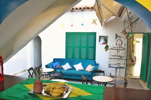 a living room with a blue couch and a table at Hostel Maresias do Leme in Rio de Janeiro