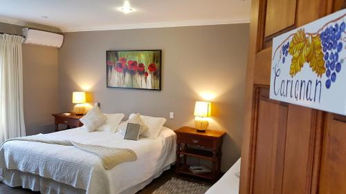 a bedroom with a bed and two night stands with lamps at Hotel Boutique Solaz Bella Vista de Colchagua in Santa Cruz