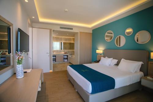 a bedroom with a large bed and a blue wall at Almyros Beach in Acharavi