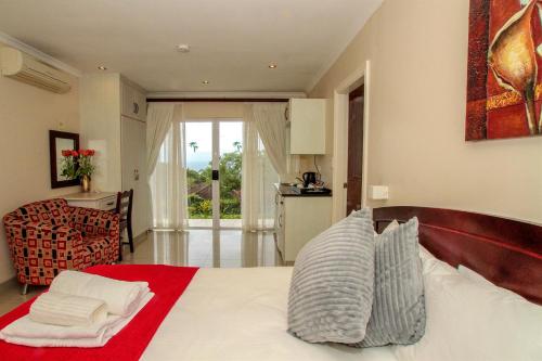 a bedroom with a white bed with a red blanket at Addis Bed and Breakfast in Durban