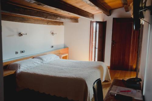 Un dormitorio con una cama grande en una habitación. en Posada Miranda, en Miranda del Castañar