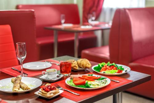 a table with plates of food on a table at Avtozavodskaya Hotel in Nizhny Novgorod