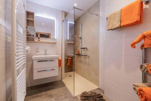 W łazience znajduje się szklana kabina prysznicowa i umywalka. w obiekcie Haus Larcher w Neustift im Stubaital