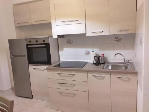una piccola cucina con lavandino e frigorifero di RIVERSIDE DA PO 9 - Appartamenti ai piedi della collina e vicino al Po a Torino