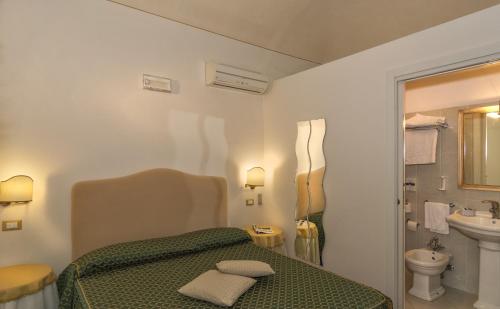 La salle de bains est pourvue d'un lit vert et d'un lavabo. dans l'établissement Il Mattino Ha L'Oro In Bocca, à Pise