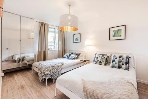 - une chambre avec 2 lits et un miroir dans l'établissement CS Apartments Bayswater, à Londres