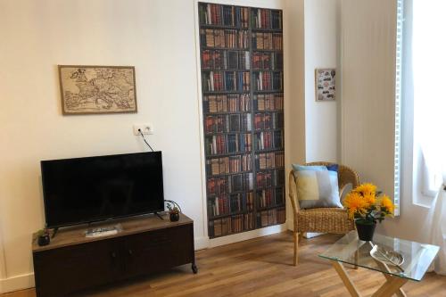 un salon avec une télévision et une étagère avec des livres dans l'établissement #M3 Irvoy's mystery Cours Jean Jaurès Tramway, à Grenoble