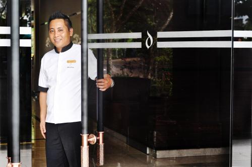 a man is standing in front of a door at Dreamtel Kota Kinabalu in Kota Kinabalu
