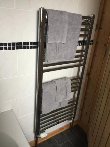 a towel rack in a bathroom with towels on it at RedWood Lodge in Ludlow