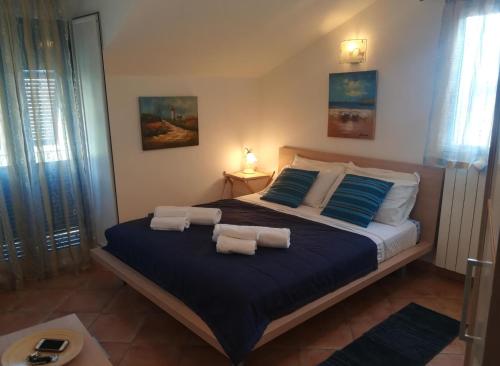 a bedroom with a large bed with blue and white pillows at House Mare e Monti by Holiday World in Albenga