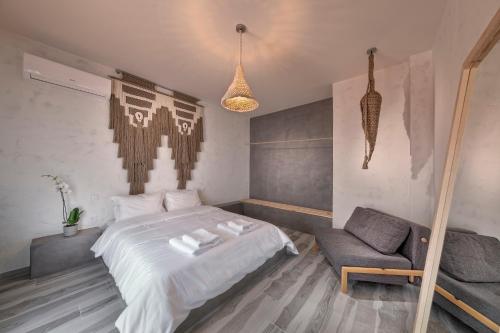 a bedroom with a bed and a chair at Macrame Suites in Tríkala
