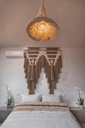 a large chandelier hanging over a bed in a bedroom at Macrame Suites in Tríkala