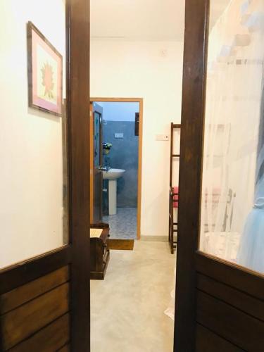 a hallway with a door leading to a bathroom at Lasindu Guest in Ahangama