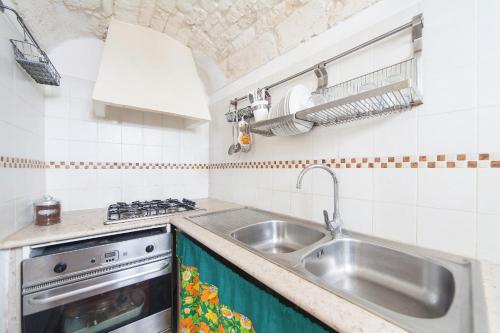 a kitchen with a sink and a stove at Casa Meravigliosa in Ostuni