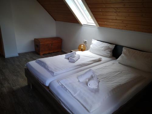 1 Schlafzimmer mit 2 Betten mit weißer Bettwäsche und einem Fenster in der Unterkunft Wolfs Gasthaus in Braunschweig