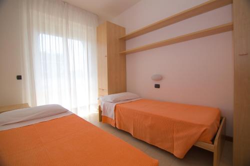 sypialnia z 2 łóżkami i oknem w obiekcie Appartamento Olimpo w mieście San Benedetto del Tronto