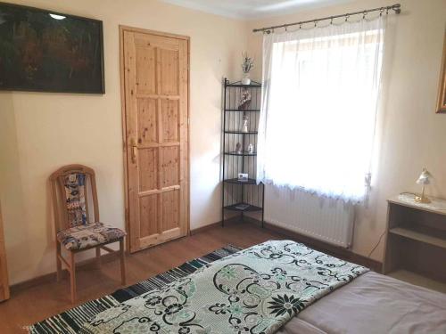 a bedroom with a bed and a window at St. Rita Guesthouse in Lókút