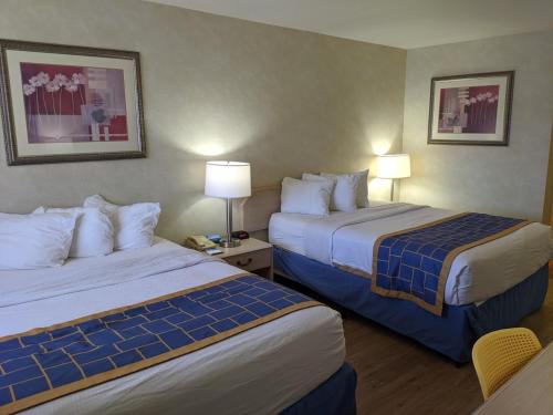 a hotel room with two beds and two lamps at Days Inn by Wyndham Bullhead City in Bullhead City