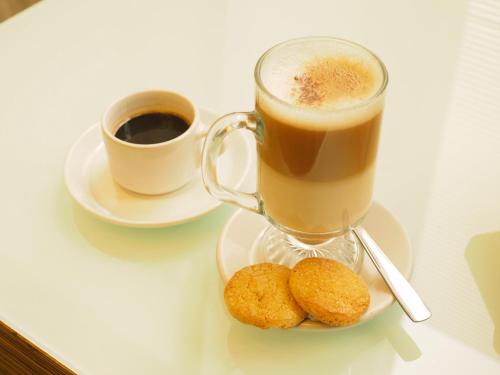 a cup of coffee and two cookies on a table at Hotel Marbella in Mexico City