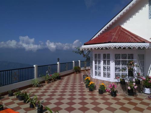 einen Pavillon auf dem Balkon eines Hauses mit Blumen in der Unterkunft Yashita Homestay in Darjeeling