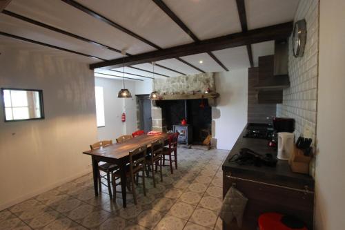 a kitchen with a table and chairs in a room at Combrailleurs in Espinasse