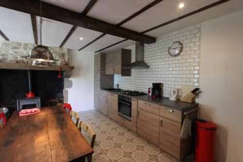 a kitchen with a wooden table and a dining room at Combrailleurs in Espinasse