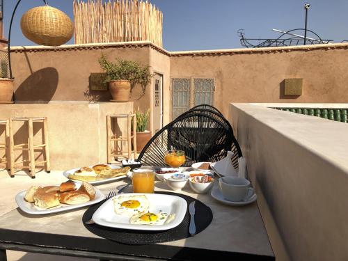 une table avec deux assiettes de nourriture sur un balcon dans l'établissement Riad Bamboo Suites & Spa, à Marrakech