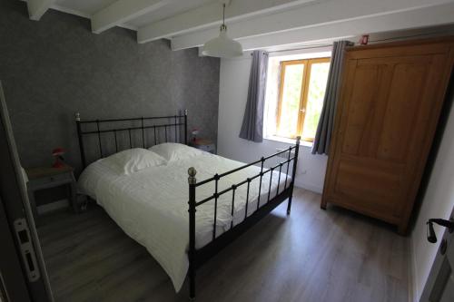 a bedroom with a bed and a window and a door at Combrailleurs in Espinasse
