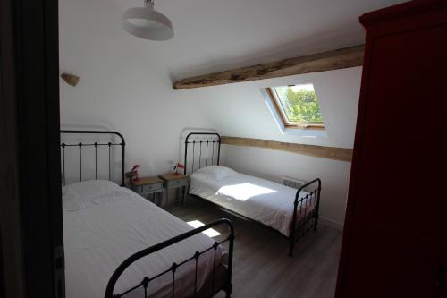 a bedroom with two beds and a window at Combrailleurs in Espinasse