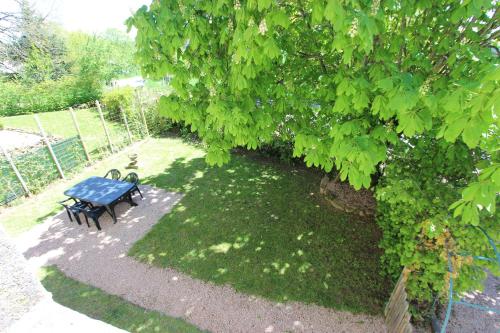 a blue table and bench under a tree at Combrailleurs in Espinasse