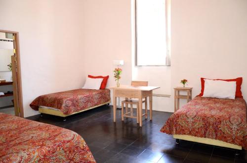 a hotel room with two beds and a table at Casa Oniri Hotel Boutique in Barichara