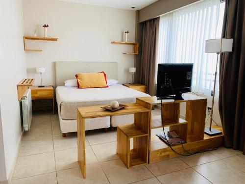 - une chambre avec un lit et un bureau avec une télévision dans l'établissement Miralejos, à Ushuaia