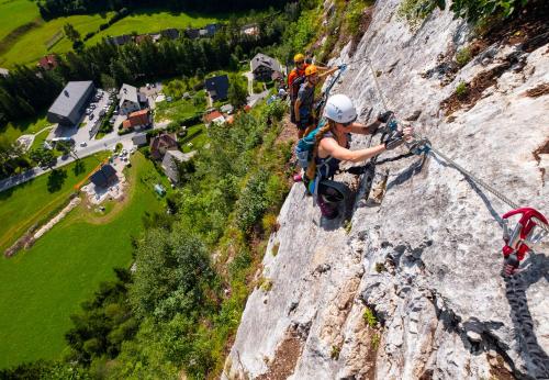 a group of people climbing on a rock formation at SavaDolinka House in Mojstrana