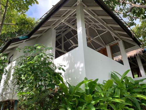 a white house with a gambrel roof at Coconut Beach Bungalows in Chaloklum