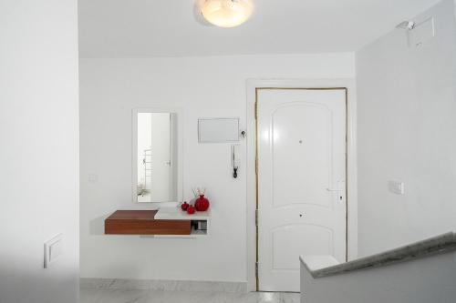 a white hallway with a white door and a table at Casa Chana in Almuñécar