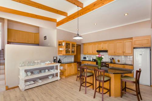 a kitchen with wooden cabinets and a table and chairs at 49 on Cliff in Gansbaai