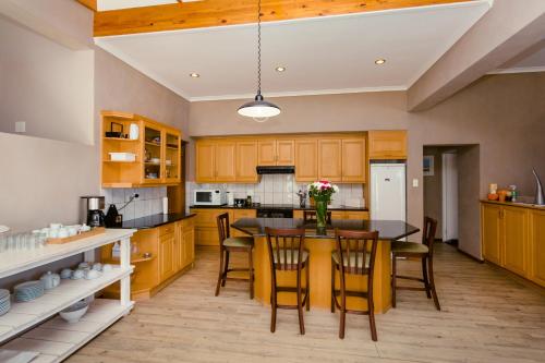a kitchen with wooden cabinets and a table and chairs at 49 on Cliff in Gansbaai
