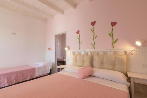 une chambre avec deux lits avec des fleurs sur le mur dans l'établissement B&B L'isola che non c'è, à Torre San Giovanni