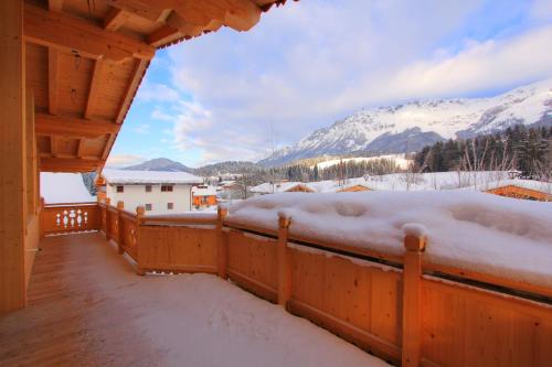 a balcony of a cabin with snow covered mountains at LuxusChalet Happy Home Tyrol in Ellmau