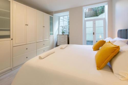 a bedroom with a large white bed with yellow pillows at Free parking! Very large 2 bedroom Clifton flat in Bristol