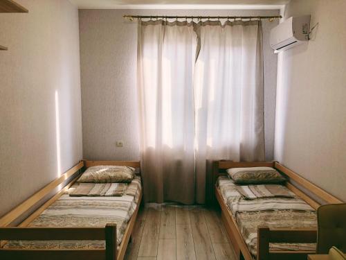 two beds in a room with a window at Annet in Kharkiv