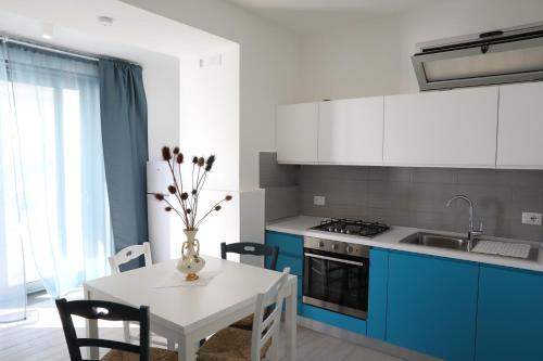 a kitchen with blue and white cabinets and a white table at Covo dei Marinai in Cava dʼAliga