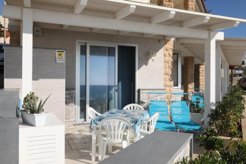 a table and chairs on a patio with a view of the ocean at Covo dei Marinai in Cava dʼAliga