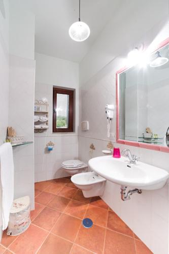 a white bathroom with a sink and a toilet at Hotel Relais Pian delle Starze in Marina di Camerota