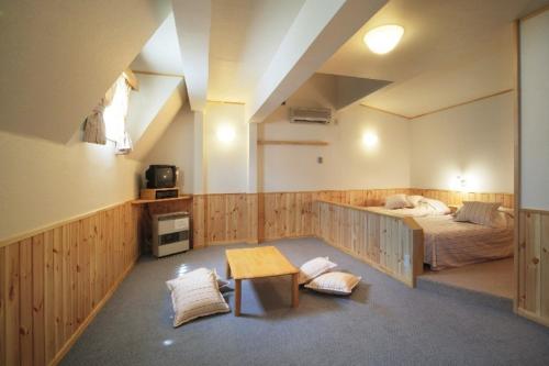 Un dormitorio con una cama y una mesa. en Pension Oz, en Yuzawa