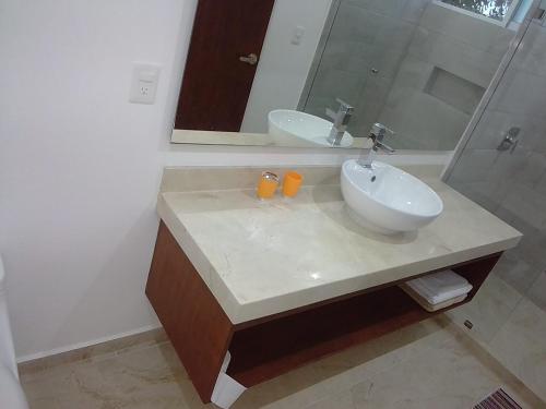 y baño con lavabo blanco y espejo. en posada tumben ka´a en Tulum