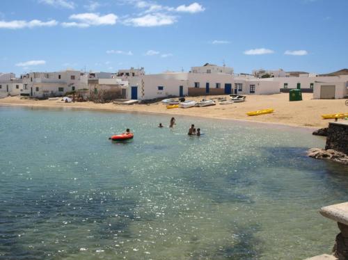 un grupo de personas en el agua en una playa en Apartamento las Crucetas, en Caleta de Sebo