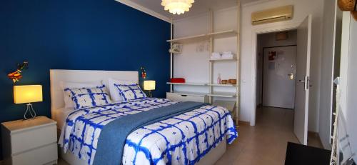 a blue bedroom with a bed and a blue wall at Apartamento Jeni Residencia Flamingo in Portimão