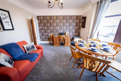 a living room with a red couch and a table at The Cobbles in Colne
